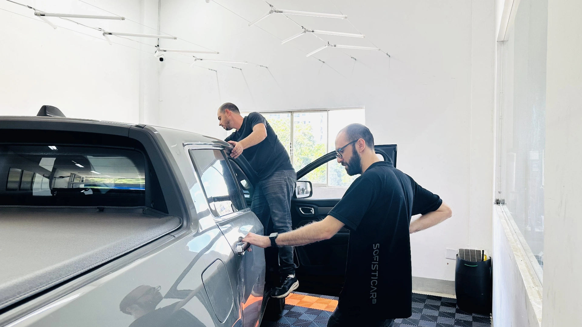 Equipe da Sofisticar instalando película em um veículo